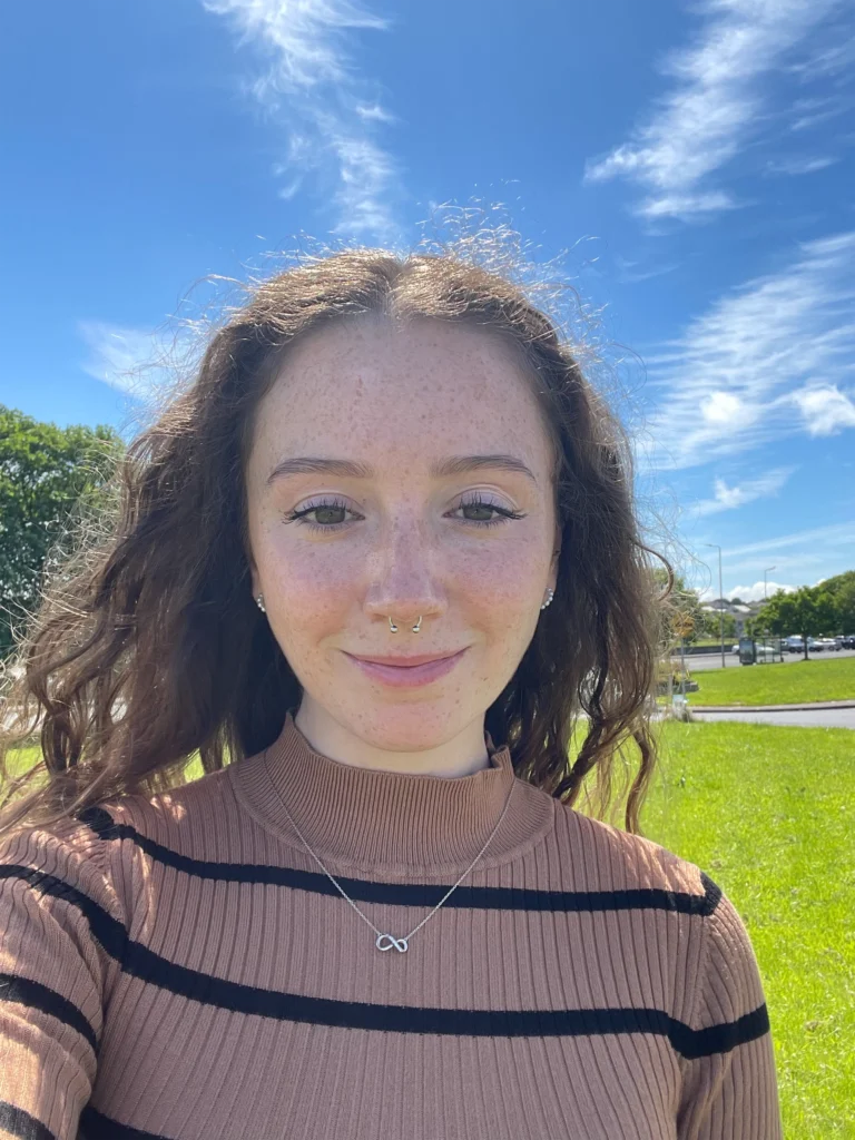 A smiling person enjoys a sunny day outdoors, promoting the Mayo Dark Sky Festival.